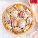 Close-up top view of apple almond tart on a light gray surface.