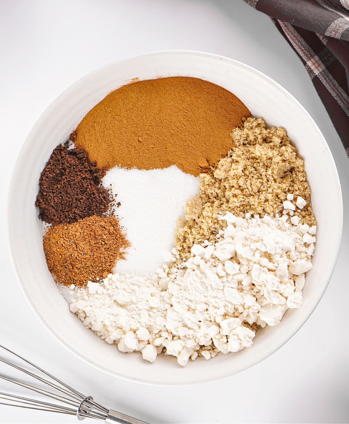 Ingredients for apple cider mix in a white bowl. Top view. White surface.