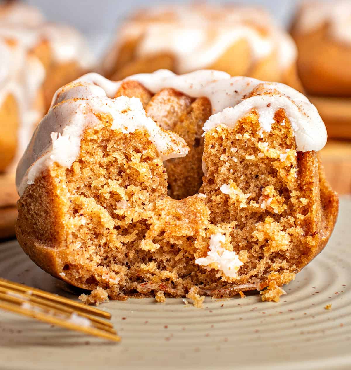 Half a glazed pumpkin mini bundt cake on a gray plate.