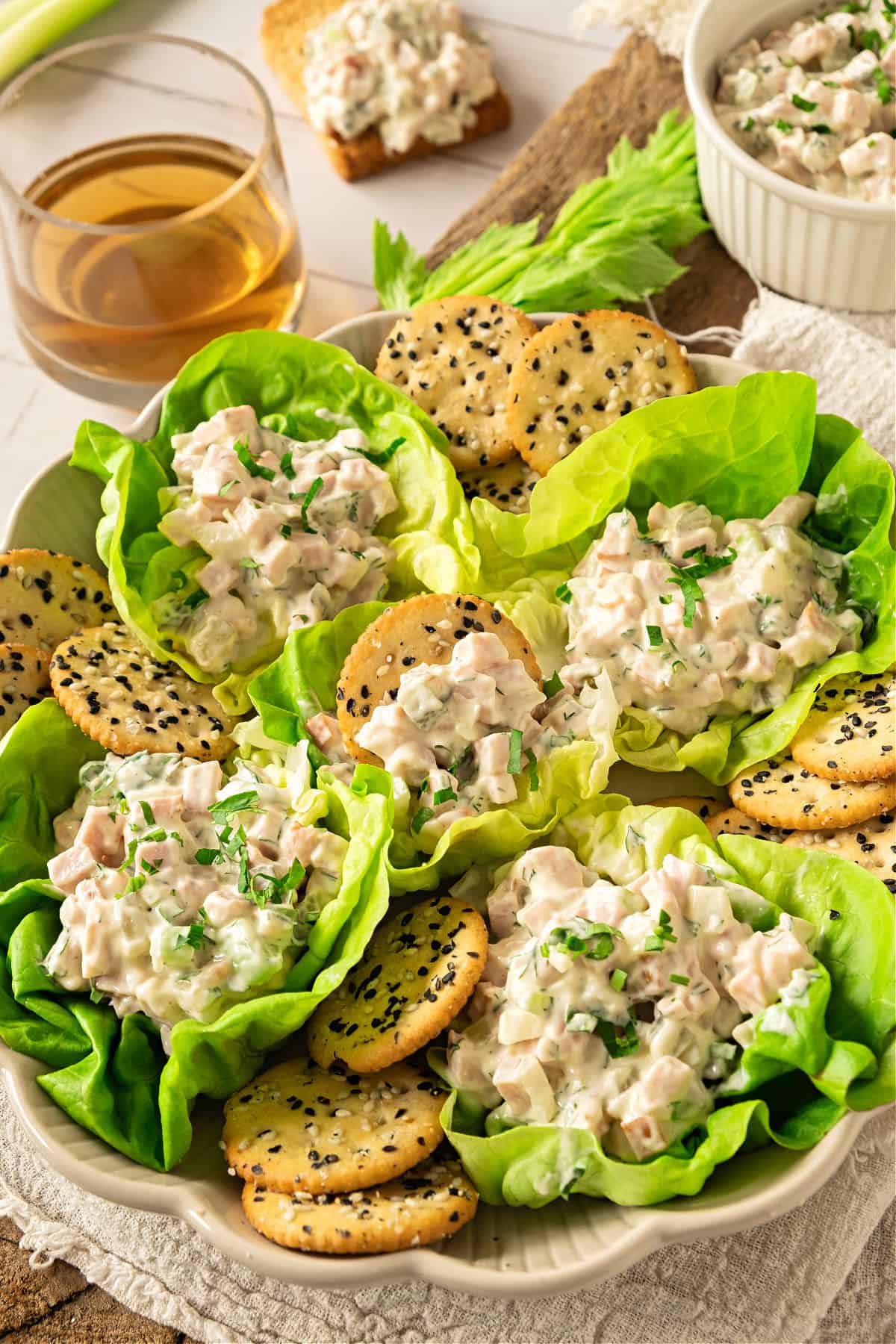 Platter of lettuce cups with ham salad. Sesame crackers around.