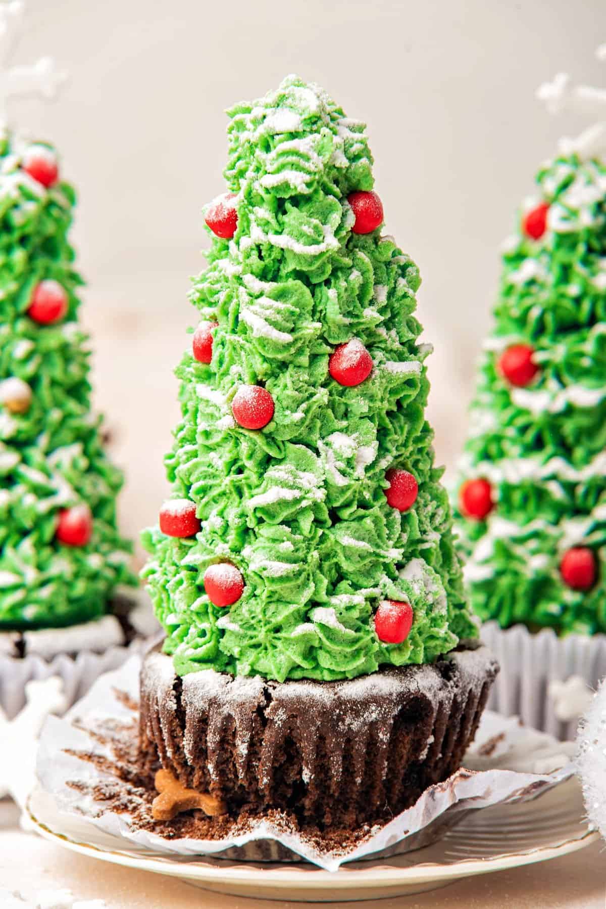 Close up Christmas tree chocolate cupcake with opened paper liner. Beige background.