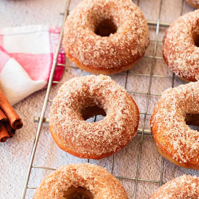 Gingerbread baked donuts on a wire rack. White background, red checkered cloth.