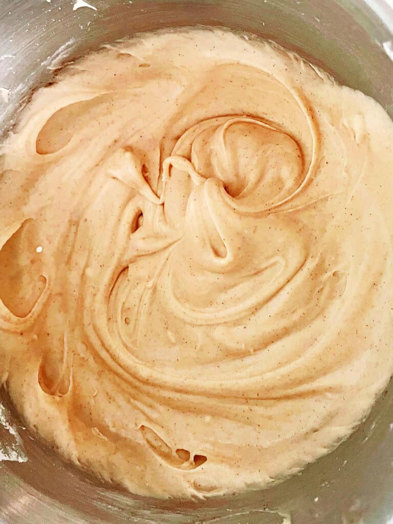 Top close up view of cinnamon frosting in a metal bowl.