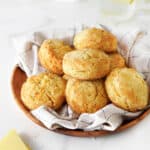 Pile of biscuits in a wooden bowl with beige checkered linen . White background.