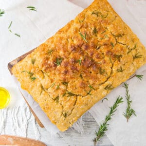 Rosemary-topped focaccia on a white surface. Top view.