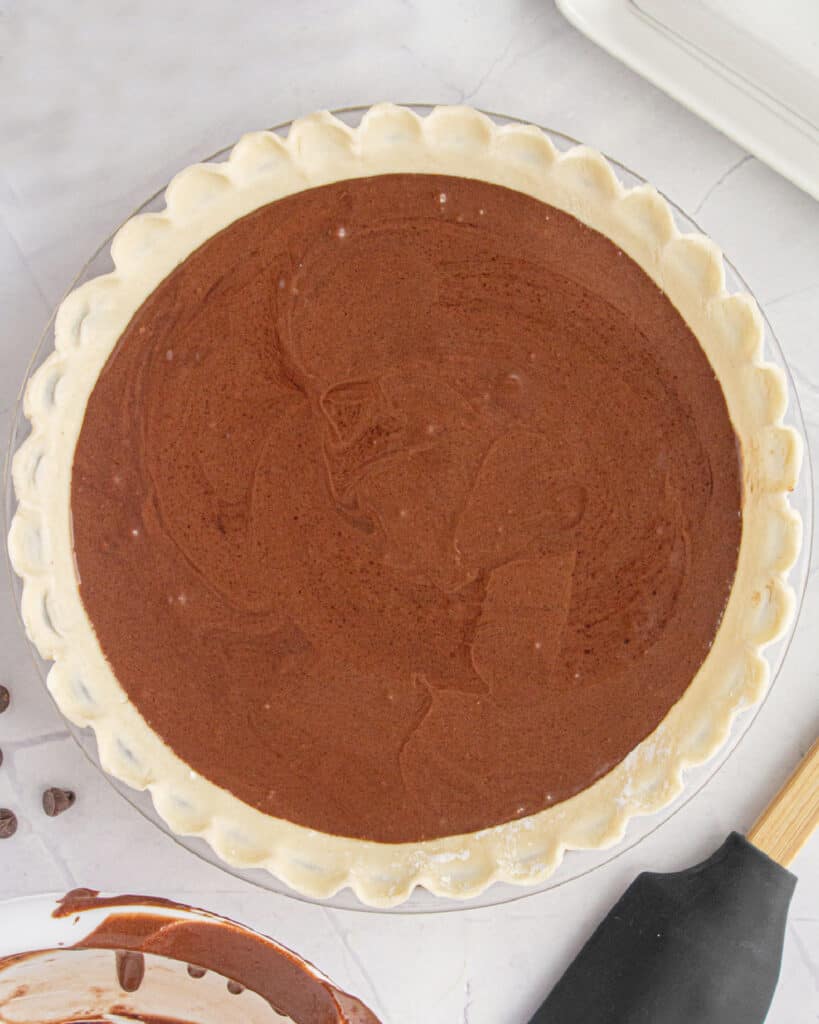 Unbaked chocolate chess pie on a white surface. Top view.