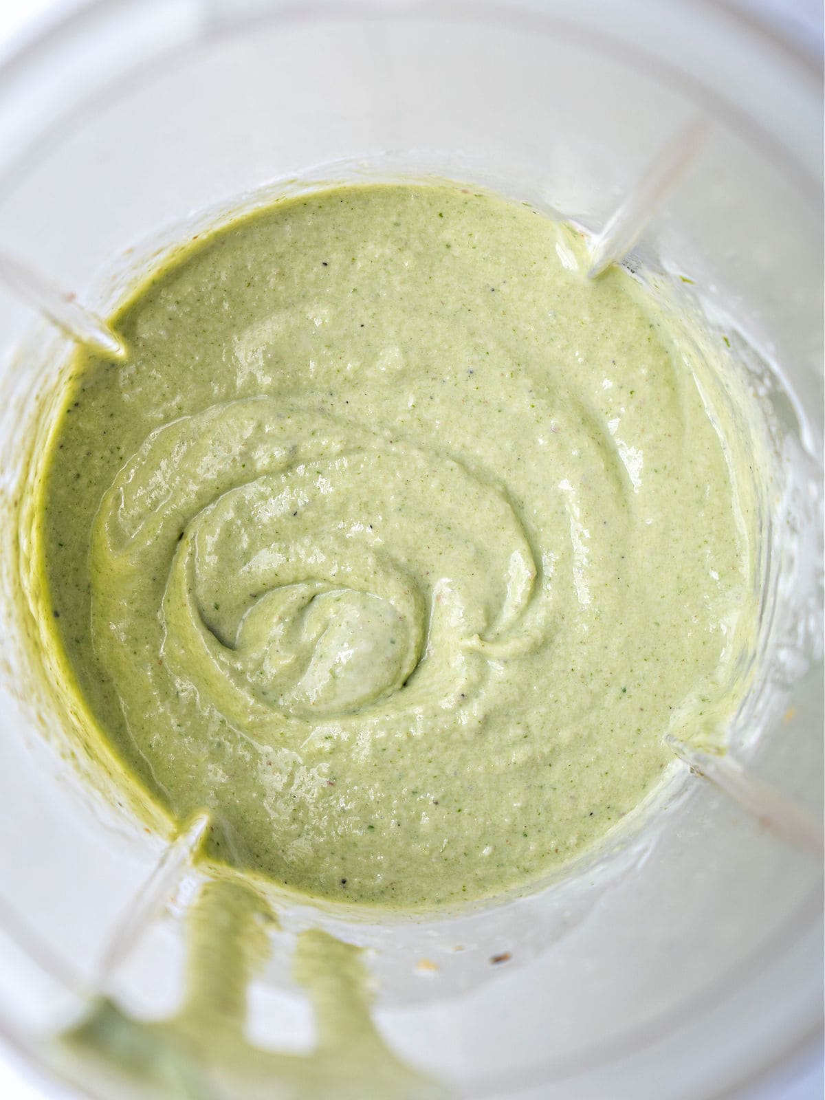 Blended creamy pesto in the jar of a blender.