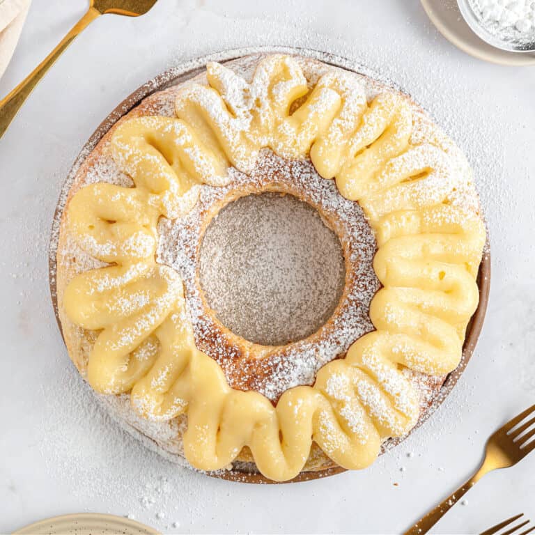 Bread ring with pastry cream on top. Light gray background.