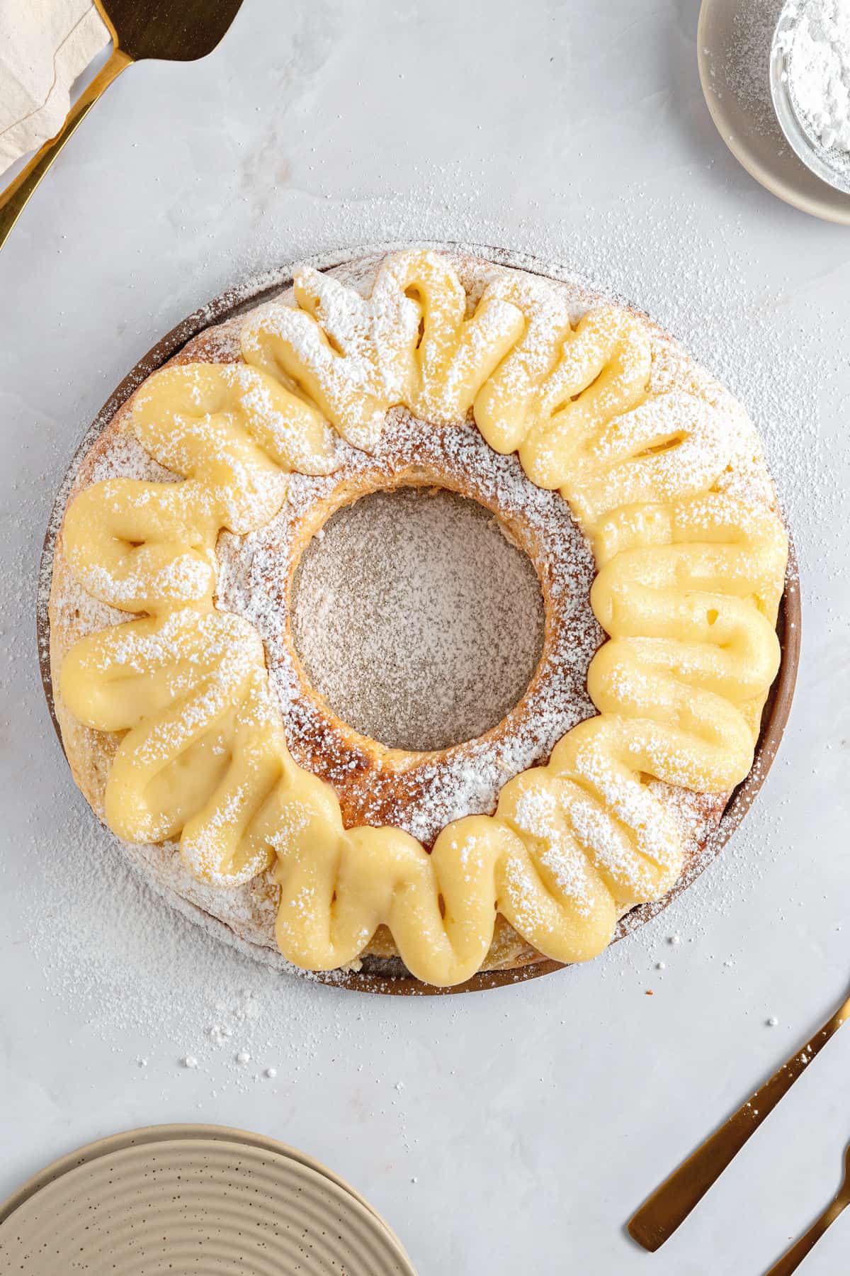 Top view of pastry cream topped Easter bread. Light gray background.