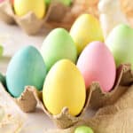 Six pastel colored eggs on an egg cartoon.