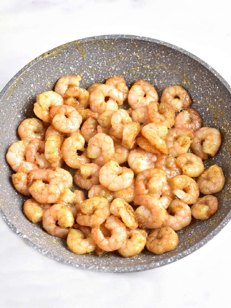 Gray bowl with cooked shrimp. White background.