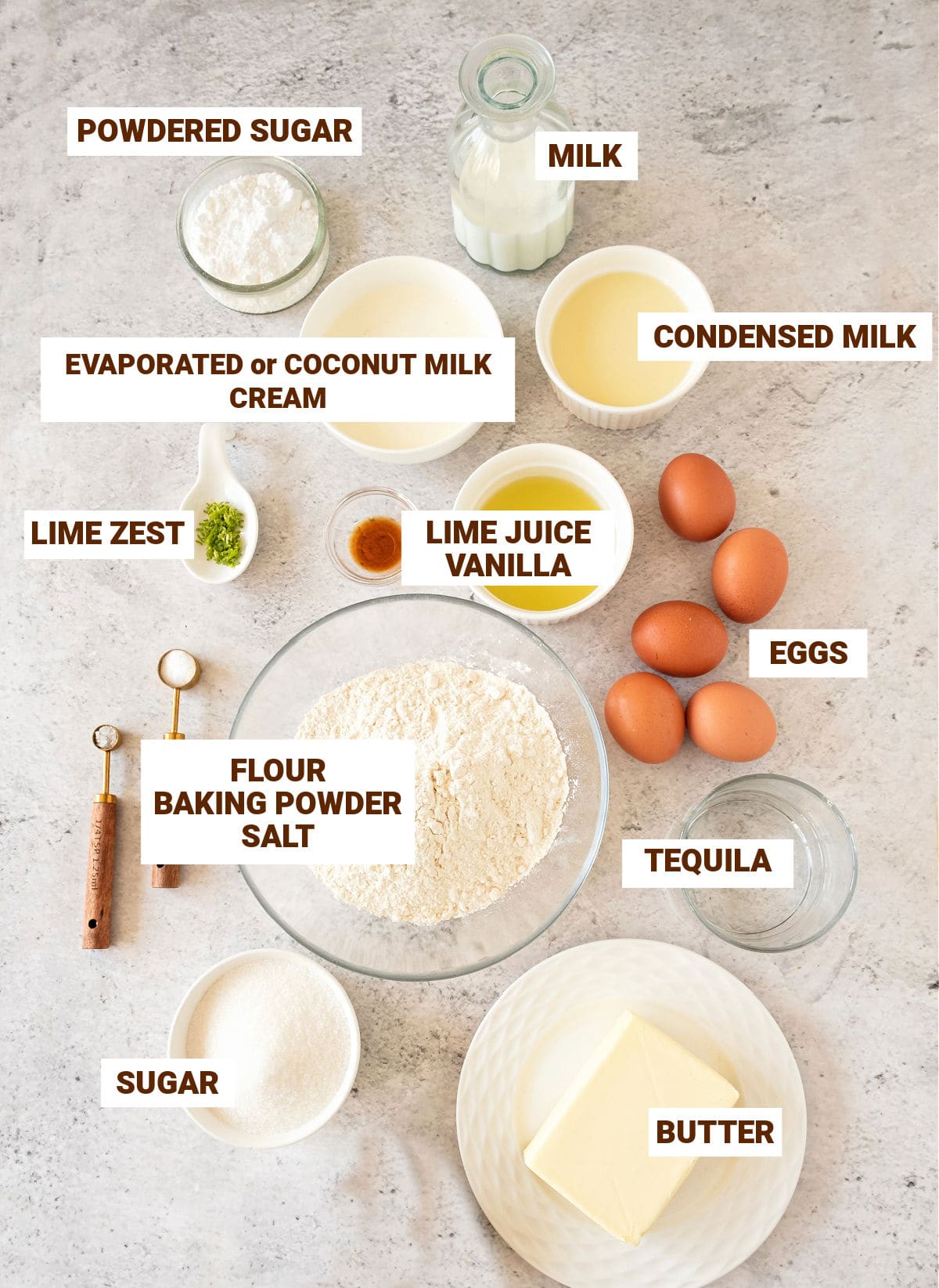 Bowls on a gray surface with ingredients for tequila lime cake with cream.