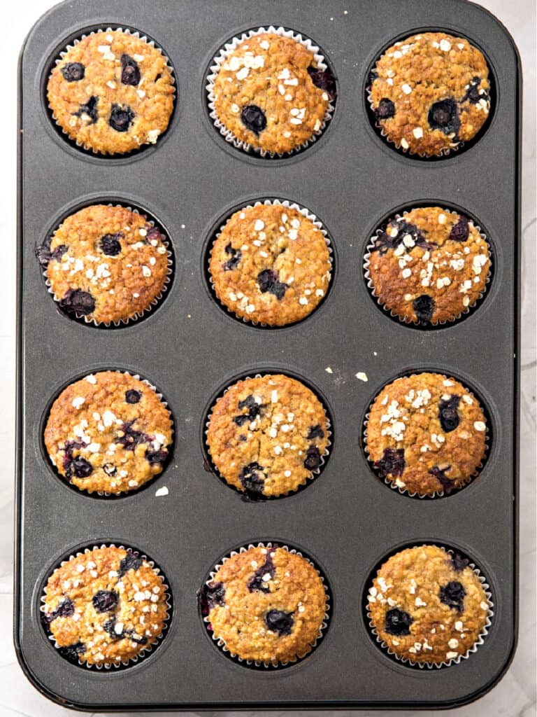 Metal pan with bake blueberry oat muffins. Top view.