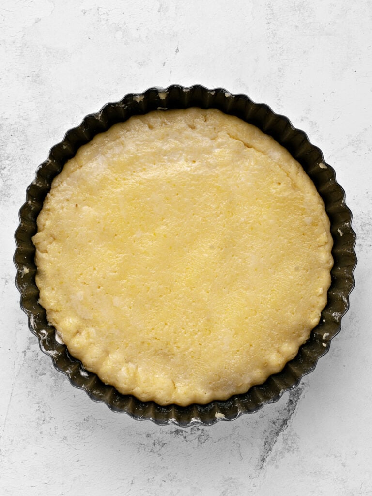 Dark pan with double crust pie before baking. Light gray background, top view.