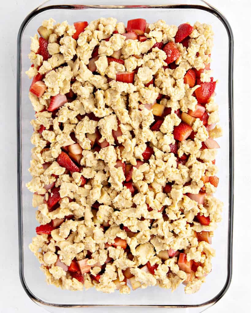 Rectangular glass baking pan with strawberry rhubarb crips before baking.