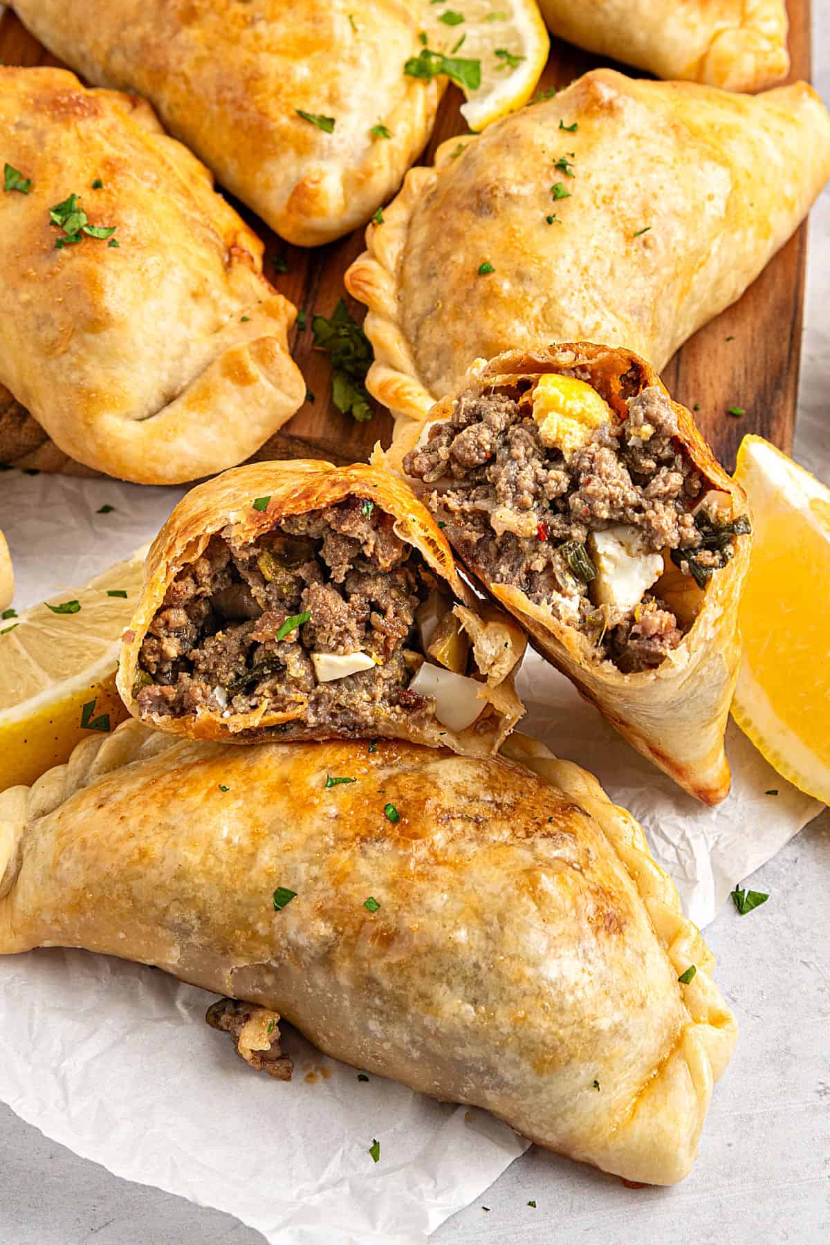 Corn Basil Handpies Several whole beef empanadas with a halved one in the middle.