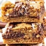 White and brown text overlay on stack of three s'mores bars.