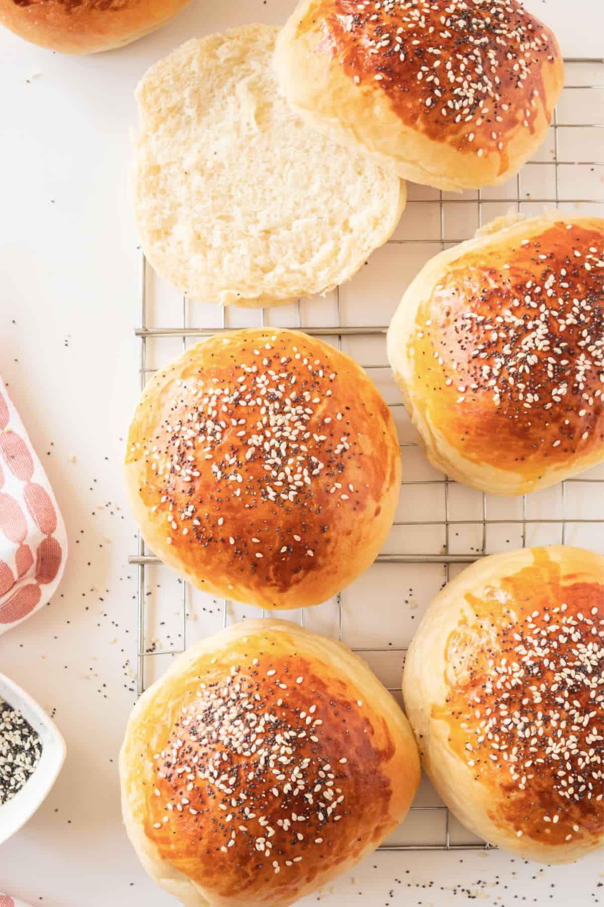 Several burger buns on a wire rack. White surface.
