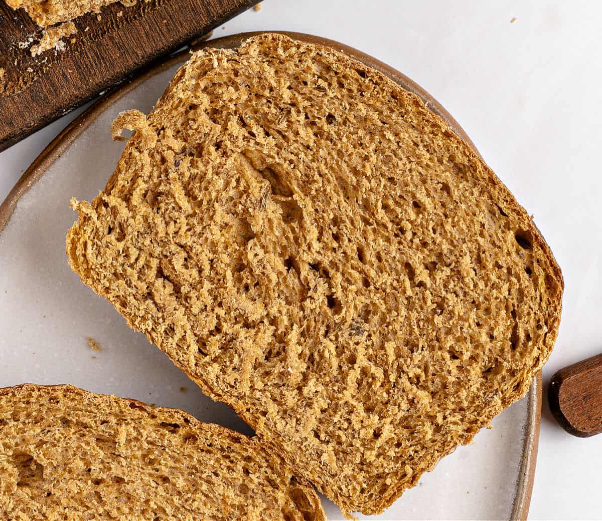 Finnish Pulla (Cardamom-scented sweet bread) Slice of rye sandwich bread on a white surface.