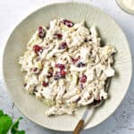 Chicken cranberry salad in a light gray plate. Silver fork.