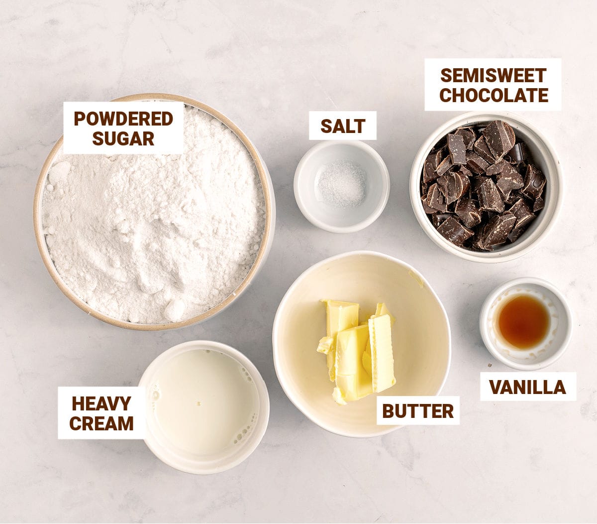 Black and white text overlay on white bowls with chocolate frosting ingredients.