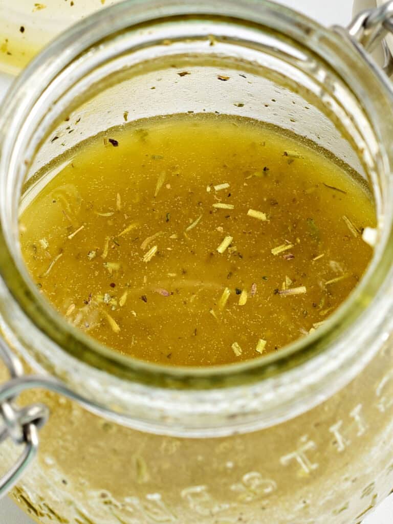 Mason jar with dressing for Greek salad.