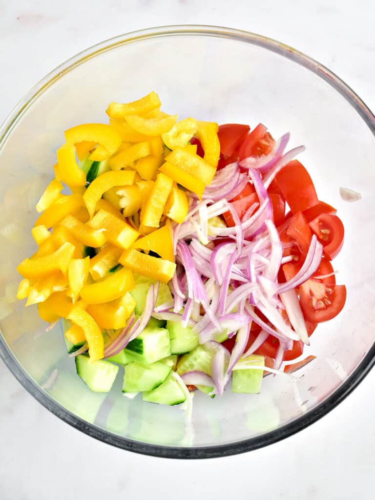 Glass bowl with chopped vegetables for Greek salad.