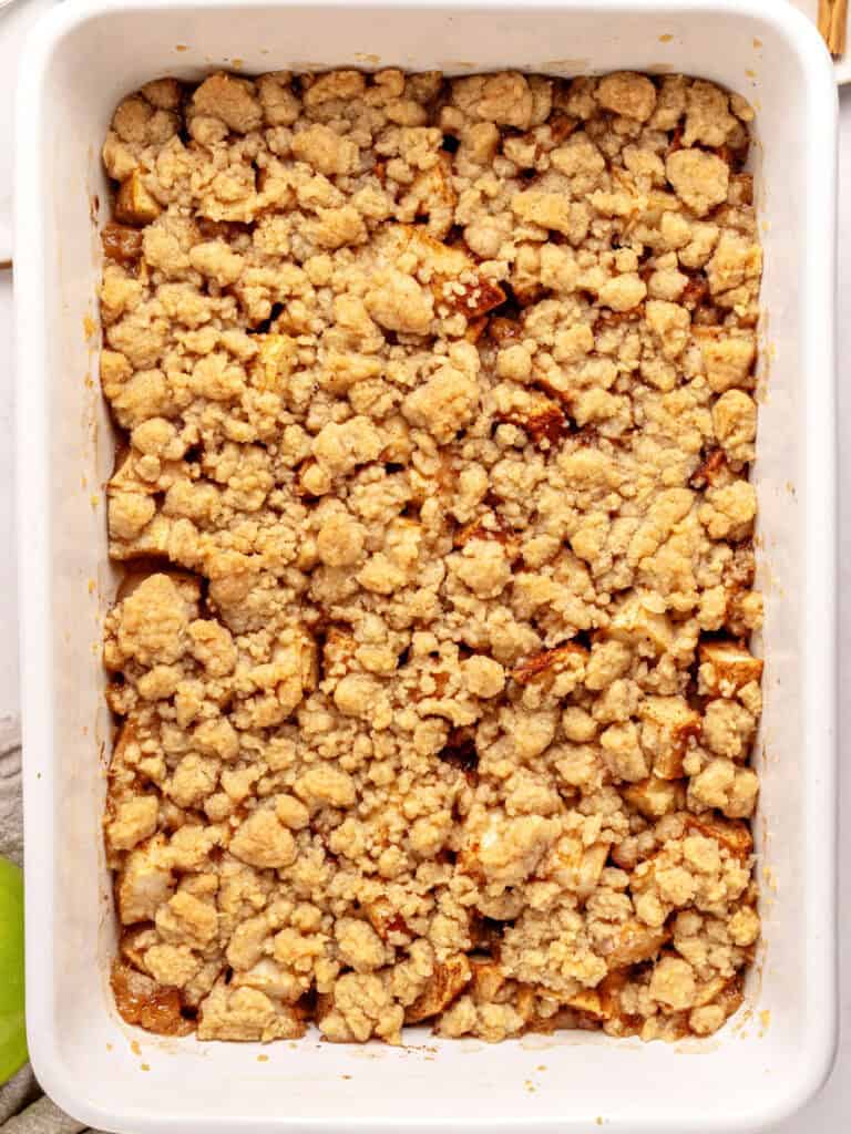 Rectangular white ceramic dish with baked apple crumble.