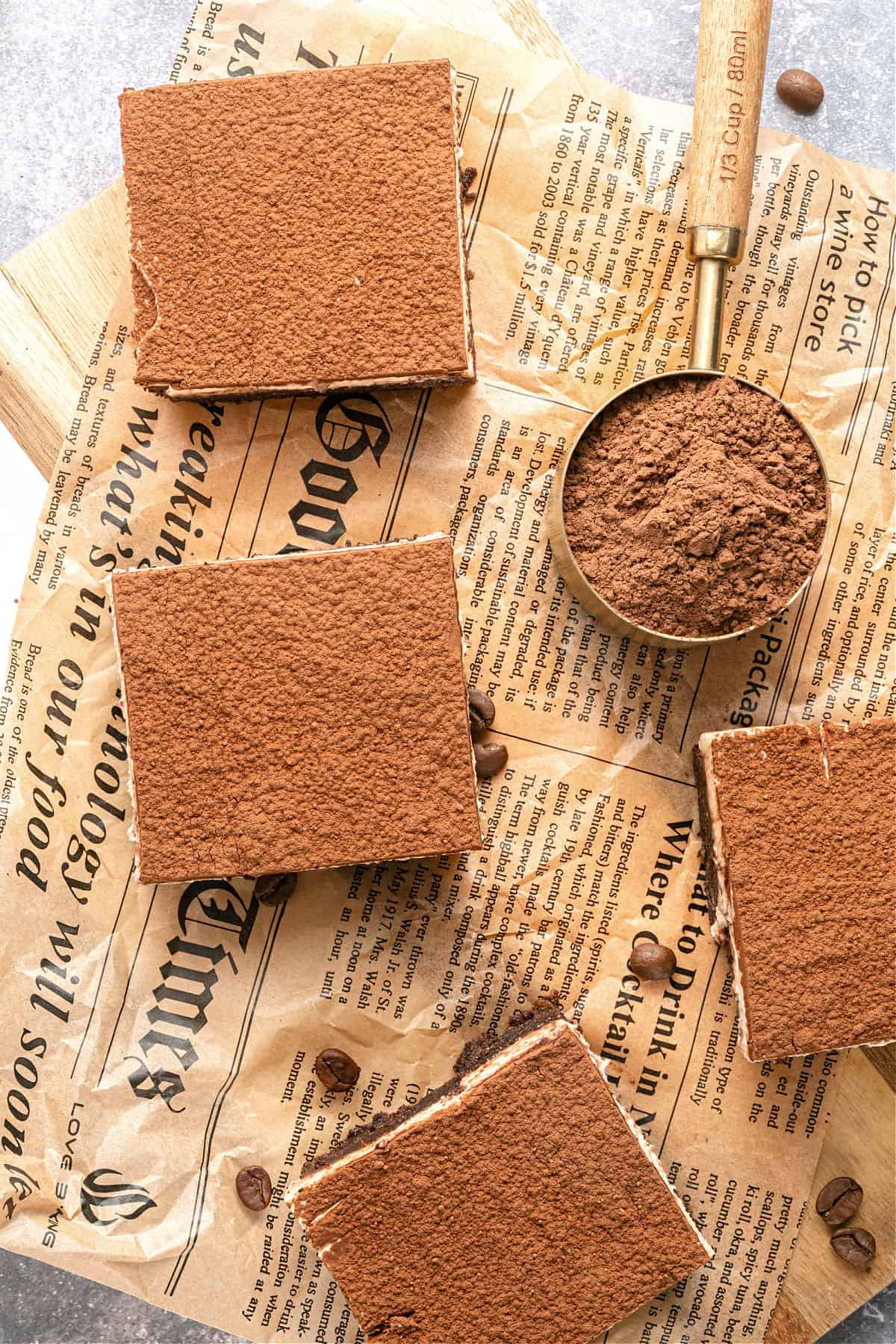 Top of newspaper sheet with squares of cocoa-topped tiramisu brownies.