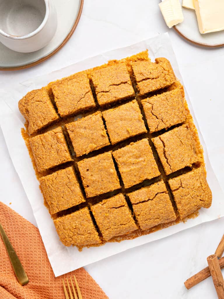 Top view of sweet potato cornbread squares on parchment paper.