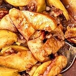 Green, white and brown text overlay on close up baked apple wedges in syrup.