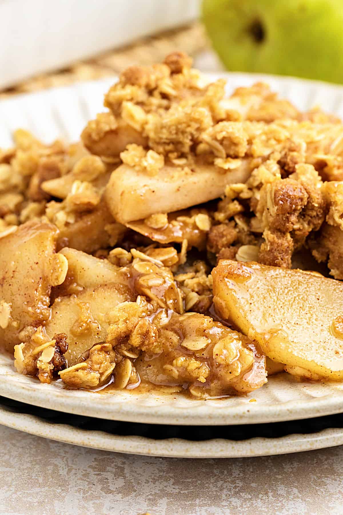 Close up serving of pear oat crisp on a white plate.