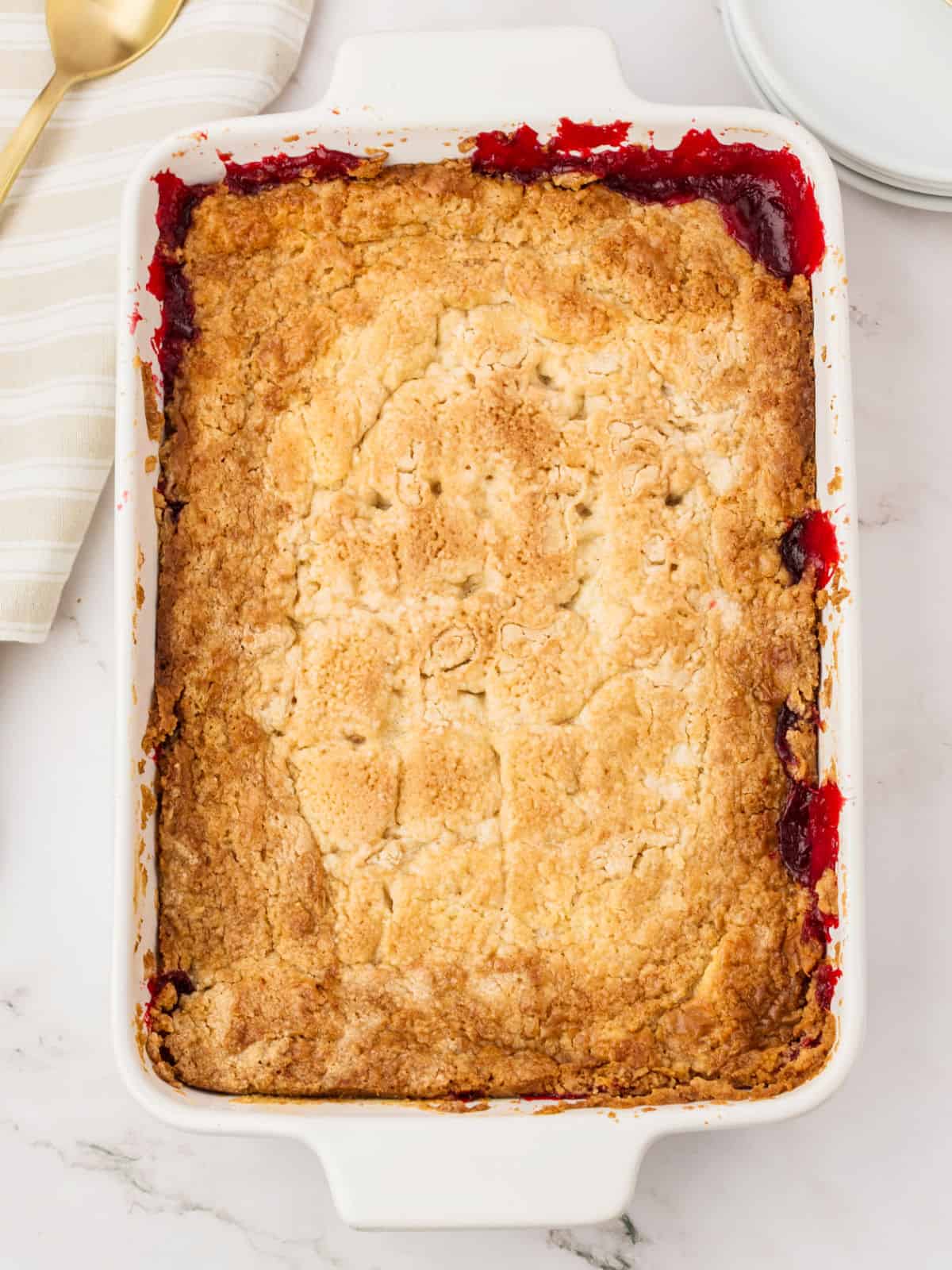 Baked strawberry cream cheese dump cobbler in a white dish.
