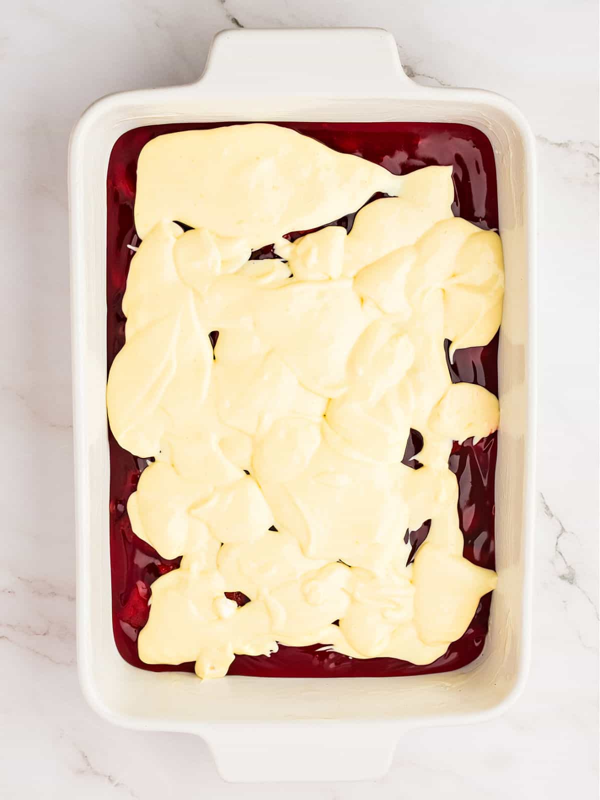 Cream cheese strawberry filling in a white baking dish. White marbled background.