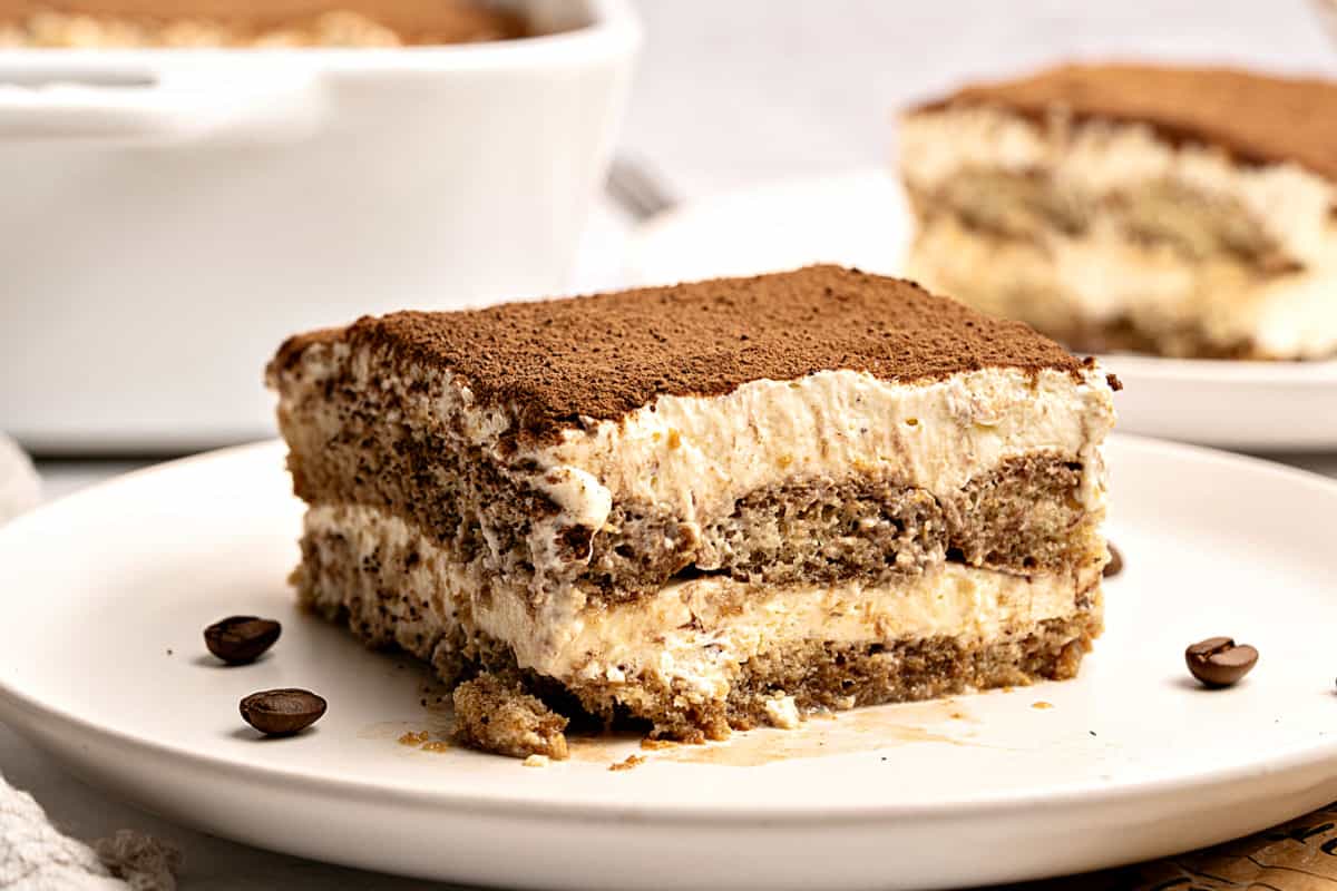 Horizontal image of mascarpone tiramisu serving on a white plate.