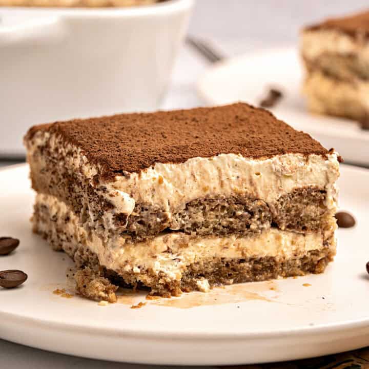 Serving of Italian tiramisu on a white plate. White background.