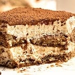 Brown text overaly on close up image of tiramisu serving.