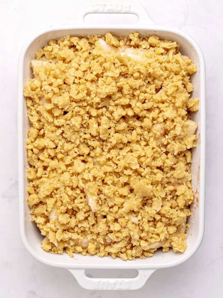 Crumble-topped pear mixture in white rectangular dish. White background. Top view.