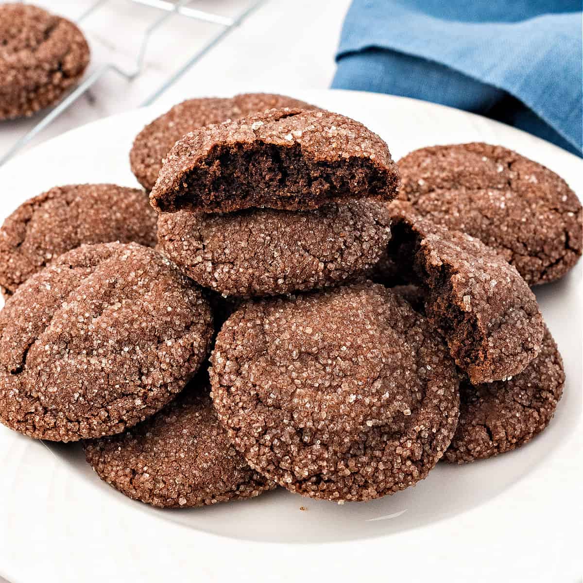 Half chocolate cookies on top of whole ones. White plate.