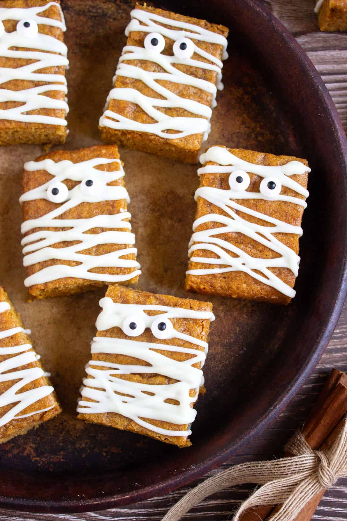 Dark tray with mummy pumpkin blondies with candy eyes.