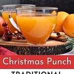 Red, white and black text overlay on glass and pot of wassail punch.