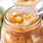Jar of apple pie filling with brown, green and white text overlay.