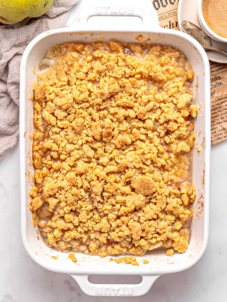 Baked pear crumble in white rectangular dish. Top view.