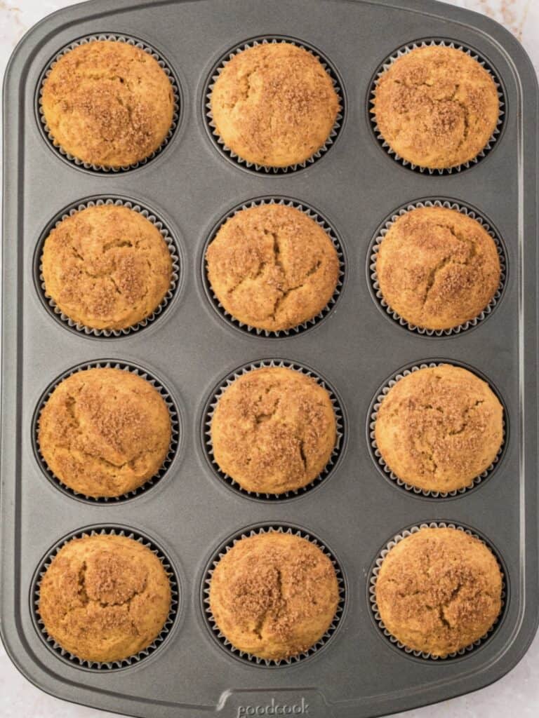 Dark tin with baked sweet potato muffins. Brown sugar crust.