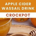 Glass jar with wassail and orange slice. Brown, red and white text overlay.