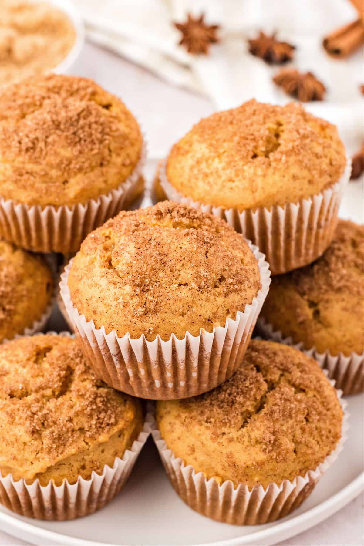 Pile of sweet potato muffins in white paper liners. White background.
