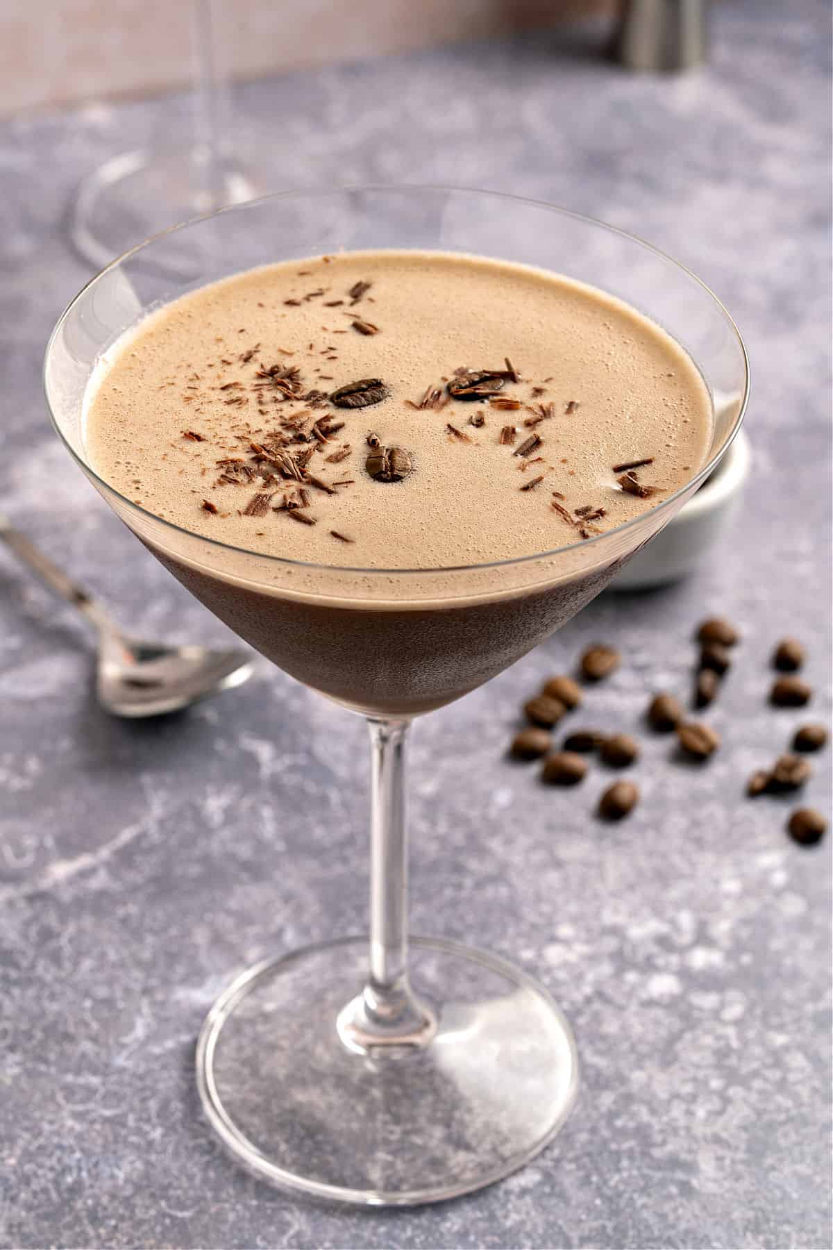 Single chocolate espresso martini glass. Textured purplish gray background.