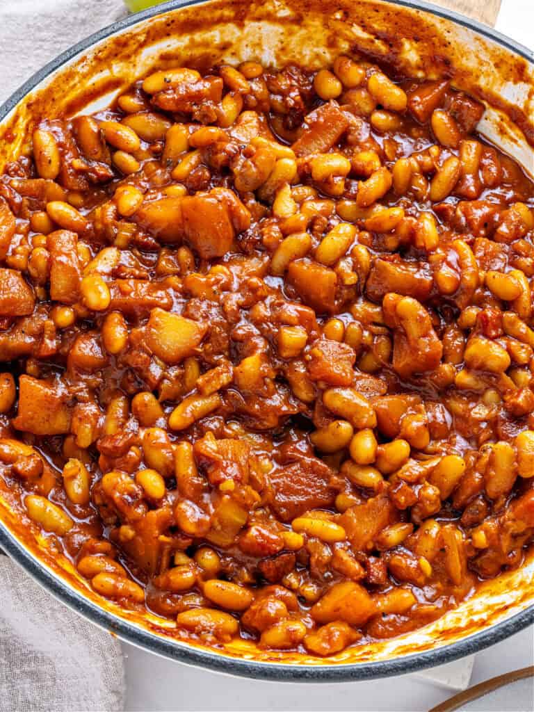 Close up beans and apples in a large pot.