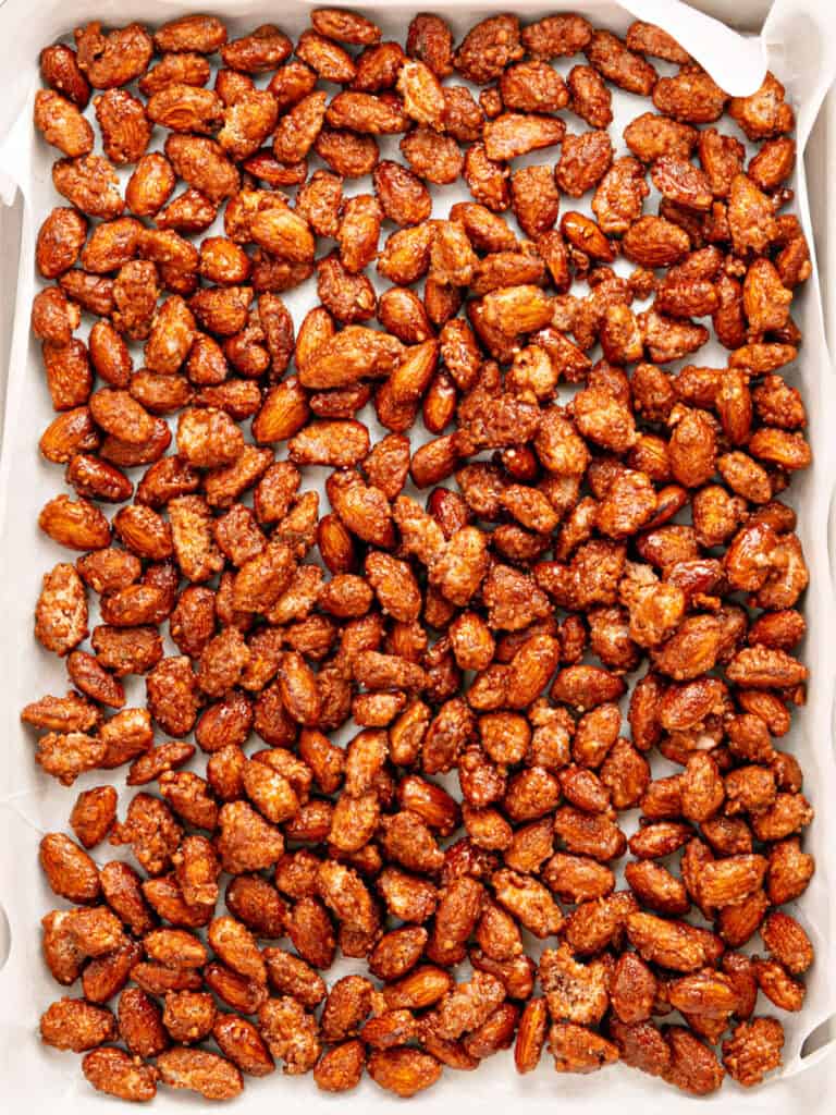 Parchment-lined baking sheet with candied almonds.