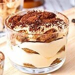 Brown, red and white text overlay on glass with tiramisu.